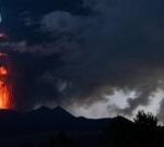 Mount Etna spits lava and smoke at dawn