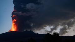 Mount Etna spits lava and smoke at dawn