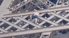 Man seen climbing Eiffel Tower above Olympics rings