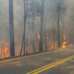 Crews battle wildfires across the US West and fight to hold containment lines